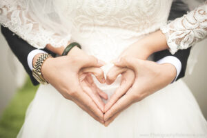 Wedding couple holding hands in heart shape